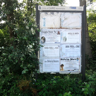 Erba alta a Cairo e non si vede il tabellone dei necrologi: le proteste dei residenti