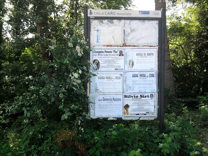 Erba alta a Cairo e non si vede il tabellone dei necrologi: le proteste dei residenti