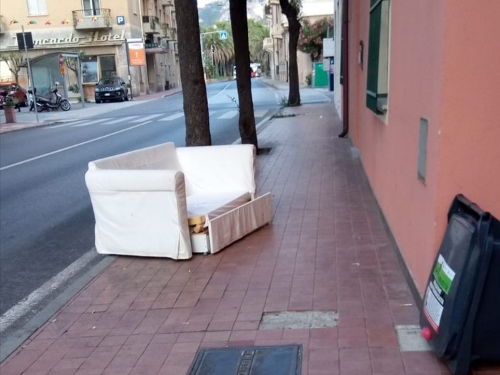 Divano abbandonato in mezzo al marciapiede in pieno centro: l'immagine tra stupore e indignazione