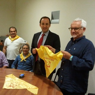 Nella foto il presidente dei “Fieui di caruggi” mentre consegna il foulard firmato da Roberto Vecchioni all’assessore regionale al Turismo Berlangieri