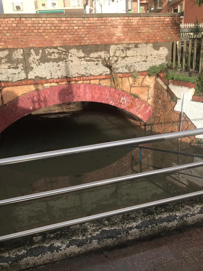 Nelle due foto: Passo Saleo allagato e gli agenti di polizia locale impegnati a rimuovere un palo divelto