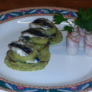 Infornata di sardelle e patate profumate con aglio prezzemolo e vino bianco su salsa verde;