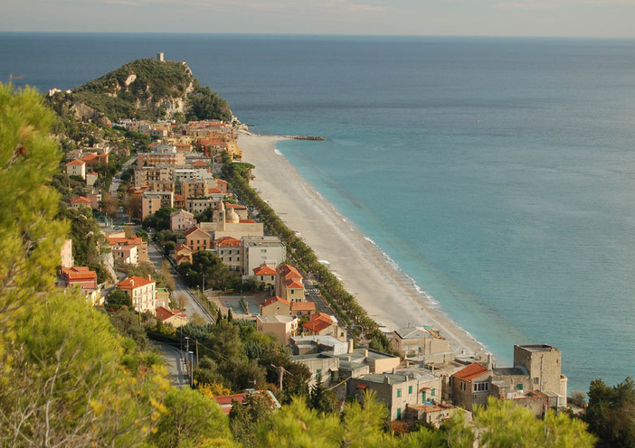 "Tra oleandri e ombrelloni, il passo lieve di una coppia fuori dal tempo nel tramonto di Varigotti"
